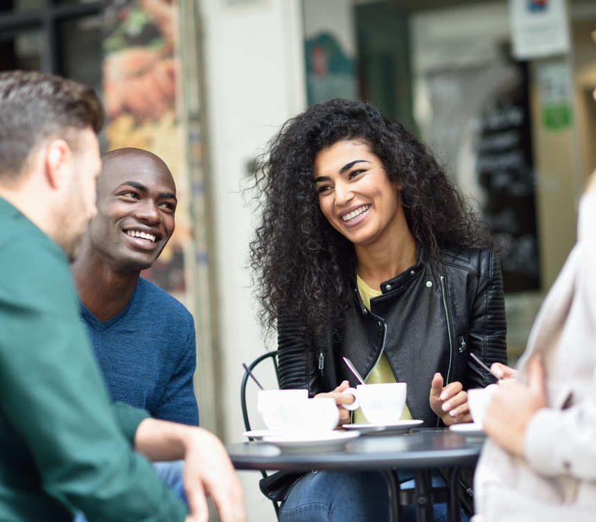 Multiracial group of four friends having a coffee together